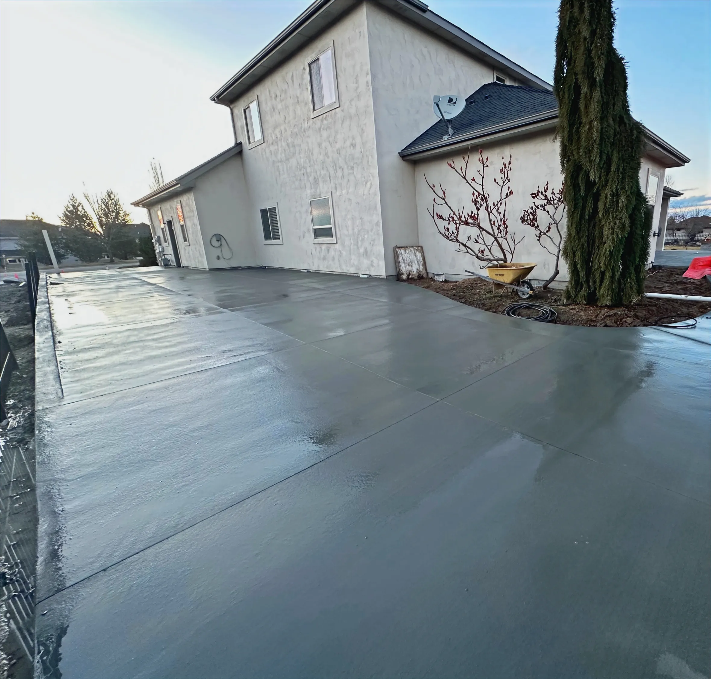 Large new concrete patio with saw-cut control joints behind a two-story home in Eagle, Idaho
