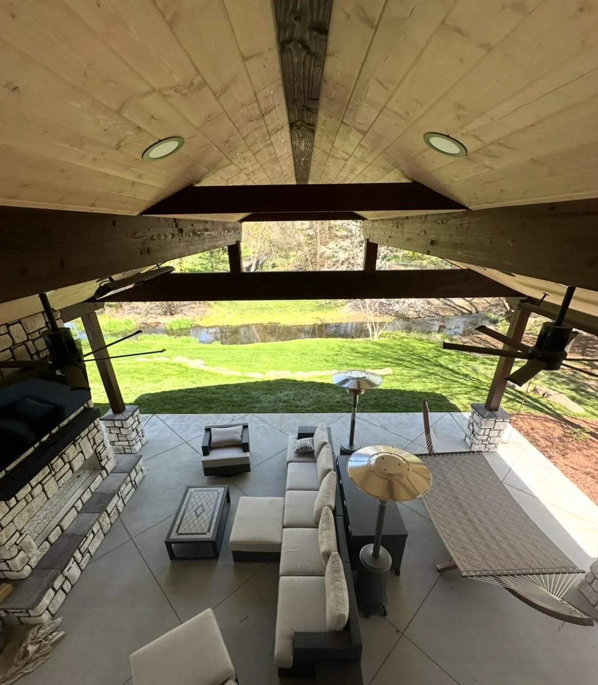 Looking up into a pavilion: tongue-and-groove ceiling, timber beams and recessed lighting